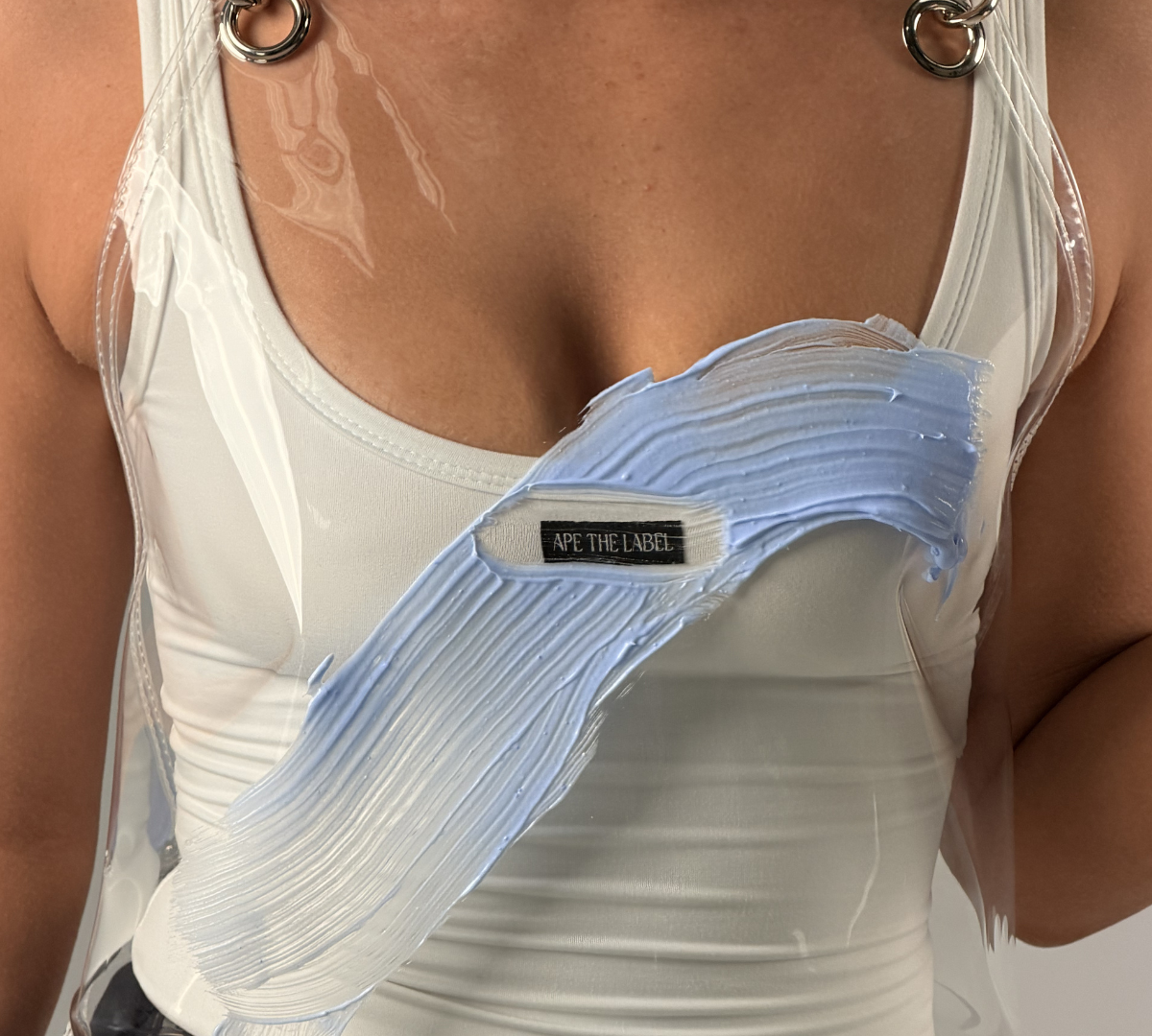 Hairdresser wearing an Ape the Label clear TPU apron with cross-back straps